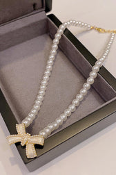 Bow Necklace With Pearl Input: Blue Striped T-Shirt Output: In Leather Wallet Coin Pocket Floral